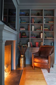 a living room filled with furniture and a fire place in front of a book shelf