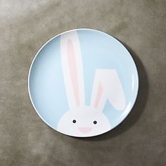 a blue plate with a bunny face painted on the front and side, sitting on a gray surface