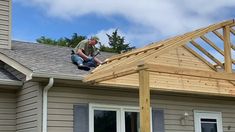 a man is working on the roof of a house that's being built with wood