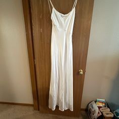 a white dress hanging on a wooden door