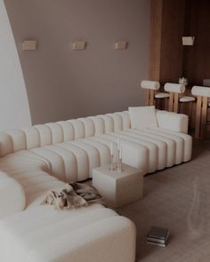 a living room filled with white furniture and lots of pillows on top of it's couches