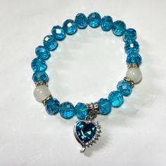 This bracelet is perfect for stacking or wearing on its own.  With sparkly heart charm strung on a stretchy cord with blue beads. Blue Bracelet With Heart And Round Beads, Blue Heart Charm Bracelets As Gifts, Blue Heart Charm Bracelet As A Gift, Blue Bracelets With Heart Charm Gift, Heart Shaped Bracelets With Faceted Beads For Gifts, Heart-shaped Bracelets With Faceted Beads For Gifts, Blue Heart Charm Bracelet For Gift, Heart-shaped Bracelet With Faceted Beads For Gifts, Blue Heart Charm Bracelet Gift