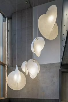 several white lights hanging from the ceiling in a room with concrete walls and flooring