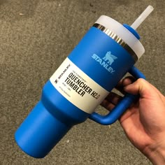 a person holding a blue and white coffee cup