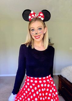 a woman in a minnie mouse costume poses for the camera with her hands on her hips