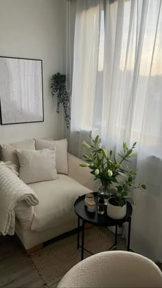 a white couch sitting next to a window in a living room