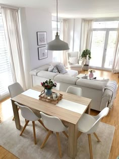 a living room and dining area with white furniture