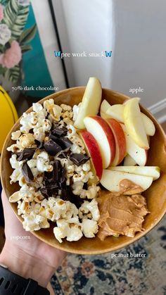 a bowl filled with popcorn, apples and chocolate chips