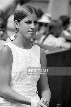 a black and white photo of a woman holding a tennis racquet in her hand