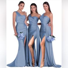 three beautiful women in blue dresses posing for the camera with their legs slited up