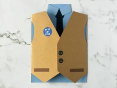 an origami style card with a tie and button on the lapel pocket