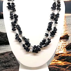 This silvery-black obsidian necklace is a masterpiece of elegance, perfect for taking your ensemble to the pinnacle of style. But it's more than just beautiful jewelry- Black Obsidian is an incredibly powerful tool, one that gently encourages reflection and self-discipline, while pushing away negativity and imbalance. 26 inches long, it's perfect for wearing double strand. Silver Obsidian Necklaces, Silver Obsidian Necklace With Natural Stones, Formal Black Necklaces With Natural Stones, Silver Obsidian Gemstone Necklace, Elegant Onyx Crystal Necklaces With Natural Stones, Elegant Black Necklace With Stones, Black Double Strand Polished Bead Jewelry, Elegant Black Beaded Necklaces With Stones, Elegant Black Stone Jewelry