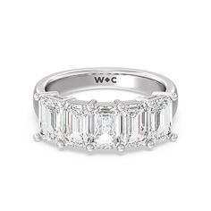 an emerald cut diamond ring with five baguetts on the band and side stones