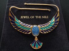 "This is a Gorgeous Vintage FM by Franklin Mint Jewel of the Nile Deep Blue Cabochon Onyx Scarab 22 Karat Gold Electroplate Enameled With Vibrant Blue and Aqua Pharaoh Necklace Ancient Egyptian Style Jewelry The Jewel of the Nile Necklace was electroplated with 22 karat gold and hand enameled with vibrant blue and aqua. At its center is an ageless symbol of good luck that dates from the time of the pharaohs in Ancient Egypt. This symbol - the scarab - was hand-carved from a color-enhanced deep b Ceremonial Blue Enamel Jewelry, Egyptian Style, Scarab Beetle, Vintage Jewelry Sets, Green Aqua, Franklin Mint, Ancient Jewelry, The Nile, Gold Chain Jewelry