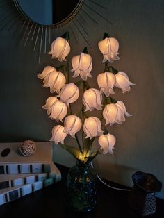 a vase filled with white flowers sitting on top of a table next to a mirror