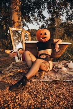 a woman sitting on the ground with her legs crossed wearing stockings and a pumpkin hat