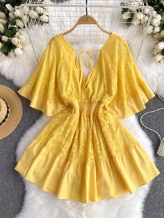 Envelop yourself in the romantic elegance of this beautiful yellow dress. Its lace detailing exudes a sophisticated charm, while the deep yellow shade offers a cheerful pop of color. The skirt flares out from a figure-hugging waist, creating a flirtatious and flattering profile. The bodice is graced with a line of delicate buttons, leading down to a ruffled hem that adds a touch of playful femininity. The open back, tied together with slender straps, offers a glimpse of skin in a tasteful displa Feminine Yellow Dress For Brunch, Yellow Lace Party Dress, Yellow Lace Dress For Brunch, Yellow Lace Dress For Party, Yellow Lace Dress For Party In Spring, Elegant Yellow Beach Dress, Elegant Yellow Lace Dress For Spring, Yellow Lace Dress For Spring, Feminine Yellow Dress For Vacation