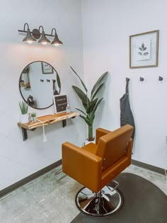 an orange chair sitting in front of a mirror next to a potted palm tree