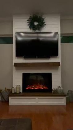 a living room with a fireplace and flat screen tv mounted above the fire in the fireplace