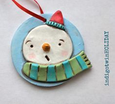 a snowman ornament hanging from a red ribbon