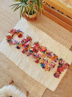 a white rug with flowers on it next to a potted plant