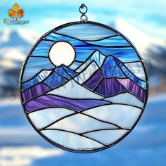 a round stained glass window with mountains in the background