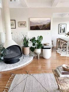 a living room filled with furniture and a fire place in the middle of a wooden floor