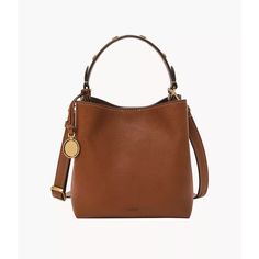 This Jessie Bucket Bag, our take on the iconic silhouette, is outfitted in brown leather that gets softer over time and features Fossil design elements, such as our Signature Knurling and engravable Legacy Charm. Wear as a top handle or a crossbody. Fossil leather products support responsible manufacturing via the Leather Working Group. Fossil Purses And Handbags, Brown Leather Bucket Bag, Fossil Purse, Small Buckets, Fossil Bags, Leather Bucket Bag, Leather Bucket, Leather Products, Dream Home Design