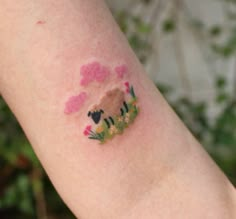 a person's arm with some pink and green paint on the top of it