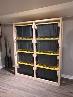 the shelves are made out of pallets and have plastic bins on each shelf