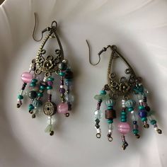 I made these spunky dangling earrings with lots of different kinds of beads, some are real crystal beads and some are just normal. I put in beads from some bracelets ive broken including a Chinese coin style bracelet. The base of these earrings include great detail and a floral design. Vintage Multicolor Beaded Dangle Earrings, Vintage Multicolor Nickel Free Beaded Earrings, Adjustable Metal Earrings With Faceted Beads, Vintage Colorful Beaded Dangle Earrings, Bohemian Crystal Earrings With Faceted Beads For Gift, Vintage Dangle Earrings With Colorful Beads, Metal Beaded Earrings With Faceted Beads For Gifts, Colorful Beaded Czech Glass Dangle Jewelry, Vintage Dangle Beaded Earrings For Festival