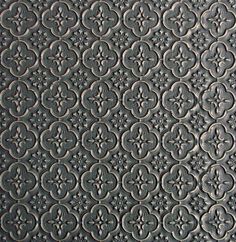 an intricate pattern is shown in black and grey tones on the surface of a tile