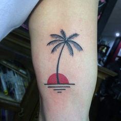 a small palm tree tattoo on the arm