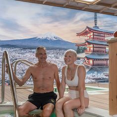 a man and woman sitting in a jacuzzi at the top of a mountain