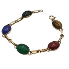 This Vintage Symmetallic Bracelet Features Intricately Carved Scarabs Set In Sterling Silver With 14k Gold Vermeil Accents. Each Scarab, Crafted From Vibrant, Colored Stones, Adds A Touch Of Elegance And Historical Significance. The Bracelet's Classic Design Is A Nod To Ancient Egyptian Artistry, Making It A Timeless Piece For Collectors. Intricate Scarab Design Sterling Silver & 14k Gold Colored Stone Scarabs Classic Clasp Closure 7.25 Inches Length Bracelet Measures 7.25 Inches In Length. Nice Scarab Jewelry, Scarab Bracelet, Colored Stone, Gold Overlay, Colored Stones, Ancient Egyptian, Charm Bracelets, Womens Jewelry Bracelets, Gold Vermeil