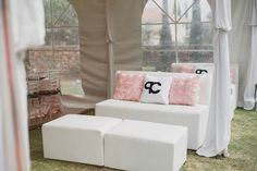 a white couch and ottoman in front of a large window with curtains on the outside