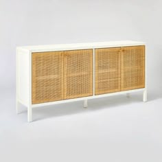 a white and brown cabinet with wicker doors