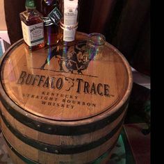 several bottles of whiskey sitting on top of a wooden barrel with the label buffalo trace