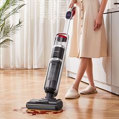 a woman is cleaning the floor with a vacuum