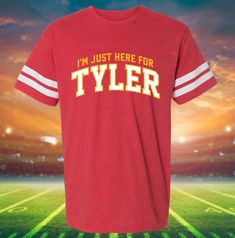 We are celebrating all things Tyler Hynes this upcoming Christmas! We can't wait to see him in his latest Hallmark Christmas movie, "Holiday Touchdown." This shirt is perfect for a movie-watching holiday party! Check out our store for more designs. **ABOUT DRESSING FESTIVE** Welcome to my shop, Dressing Festive! I've been selling festive tees on my website for a while now, but recently started an Etsy Store, so welcome to my page! Here at Dressing Festive, we believe in celebrating in style all year long. Check back often for new designs for all your favorite holidays and not-so-official holidays. You'll find that we are your go-to place for almost every occasion and for designs featuring your favorite feel-good TV Movies! Make sure to check out our other designs on Etsy! **ABOUT OUR DESIG Red T-shirt With Name Print For Game Day, Red Team Spirit T-shirt With Name Print, Red Varsity T-shirt For Fan Gear, Red Tops With Name Print For Sports Events, Red Varsity T-shirt With Team Name, Red Tops With Text Print For Sports Season, Red Cotton Team Shirt, Game Day Red T-shirt With Name Print, Varsity Fan Gear T-shirt With Name Print