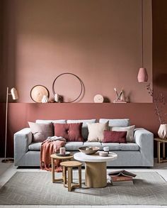 a living room filled with furniture and pink walls