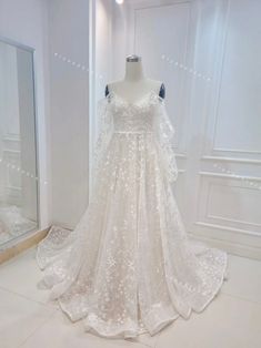 a white wedding dress on display in a room