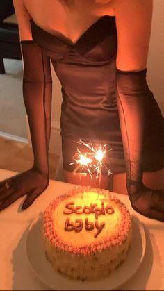 a woman in tights is looking at a birthday cake with sparklers on it