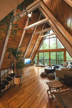 a living room filled with furniture and lots of wooden flooring next to tall windows