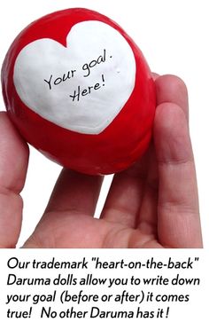 a hand holding a red and white heart - shaped ball with the words your goal here written on it