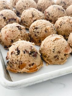 a tray filled with cookies and muffins on top of a white countertop