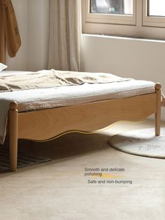 a bed sitting on top of a wooden floor next to a window