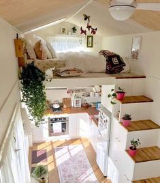 a small loft with stairs leading up to the bed area and kitchen in the background