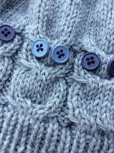 three buttons are attached to the back of a knitted sweater