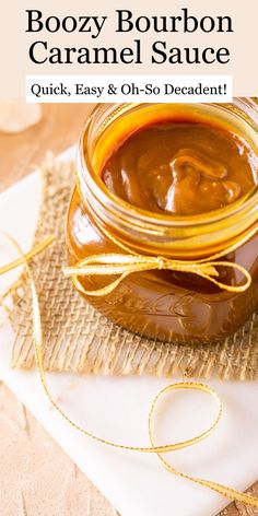 a jar filled with boozy bourbon caramel sauce on top of a white plate